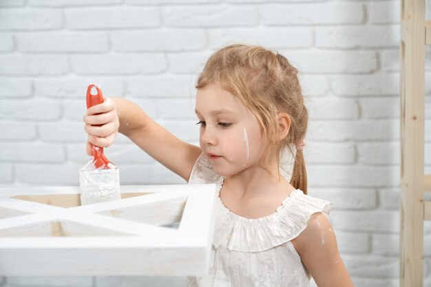 Cute little girl painting rack in white color