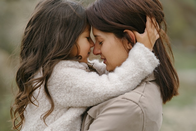 Cute little girl. People walks outside. Woman in a brown coat.