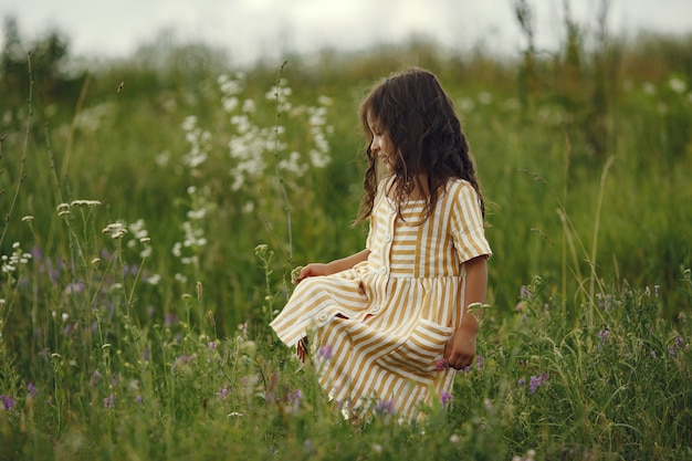 Bambina sveglia che gioca in un campo estivo