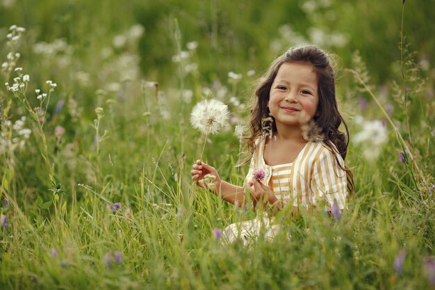 Милая маленькая девочка играет в летнем поле