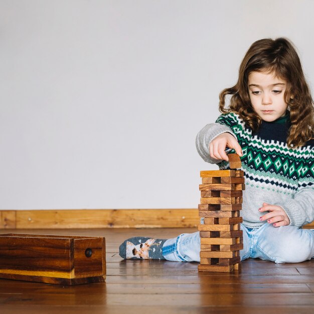 Cute little girl playing wooden block game