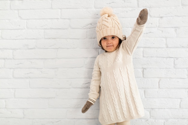 Cute little girl posing in front of a wall