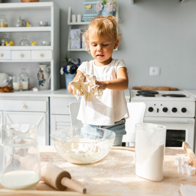Cute little girl preparing dough