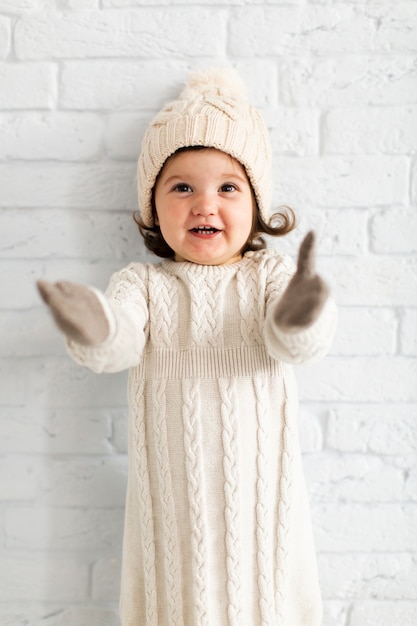 Free photo cute little girl raising her hands