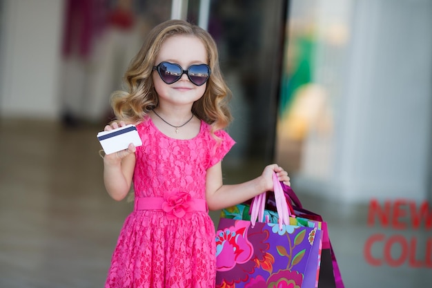 милая маленькая девочка делает покупки на улице