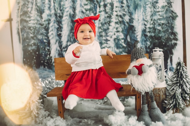 Cute little girl sitting in a christmas decorations