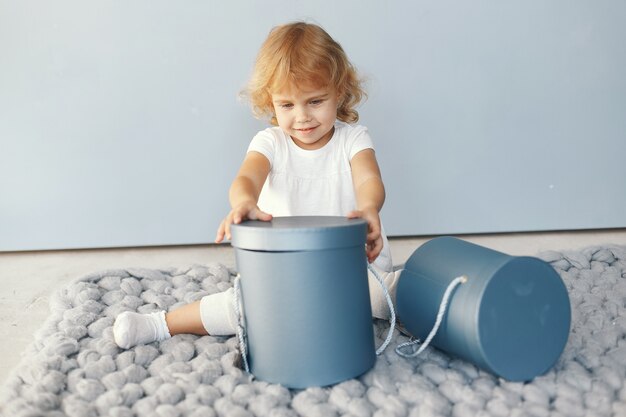 Cute little girl sitting in a studio with presents box