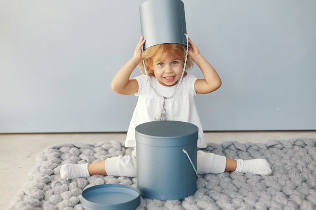 Cute little girl sitting in a studio with presents box