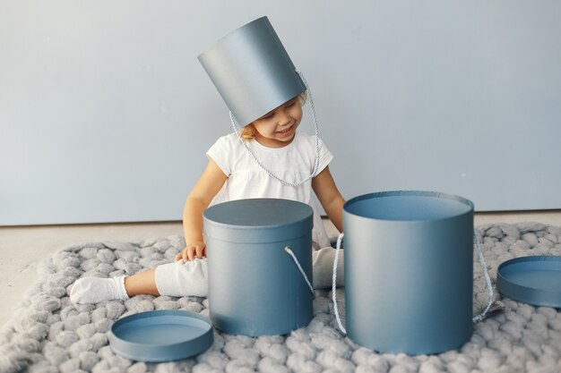 Cute little girl sitting in a studio with presents box