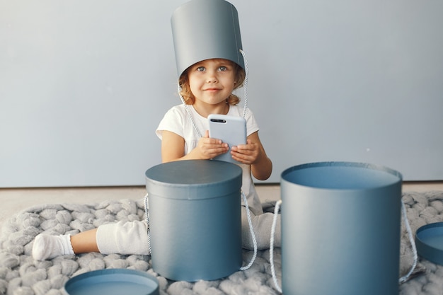 Foto gratuita bambina sveglia che si siede in uno studio con la scatola dei presente