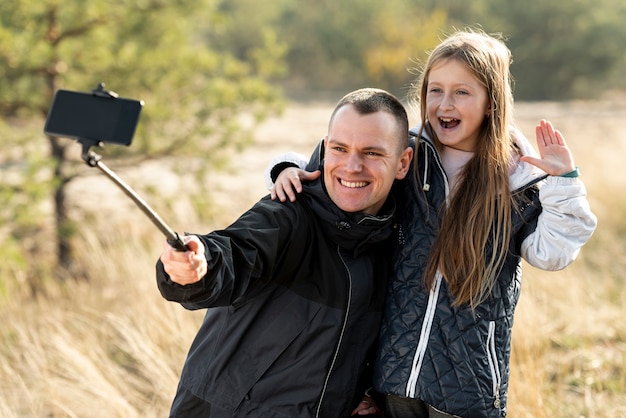 Free photo cute little girl taking a selfie with her father