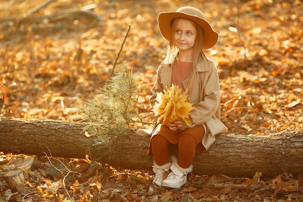 Foto gratuita la bambina sveglia cammina in un parco di autunno