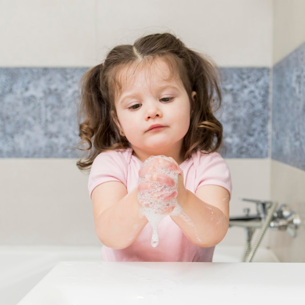 Cute little girl washing hands