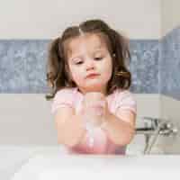 Бесплатное фото Милая маленькая девочка моет руки