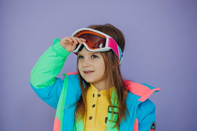 Cute little girl wearing ski wear isolated in studio