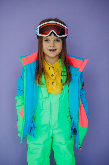Cute little girl wearing ski wear isolated in studio