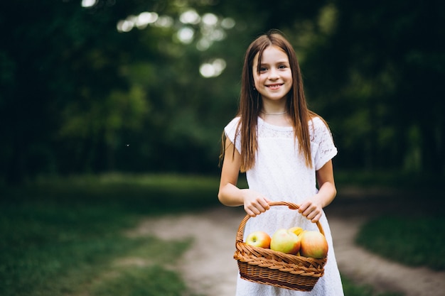 Cute little girl with basket of fruit