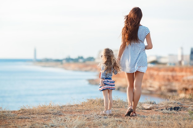cute little girl with mother near the sea