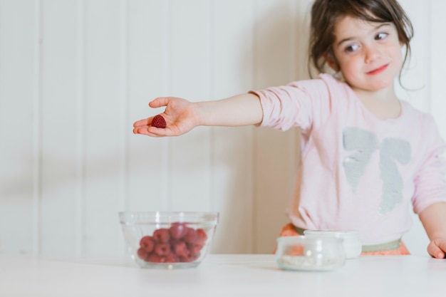 Cute little girl with raspberry