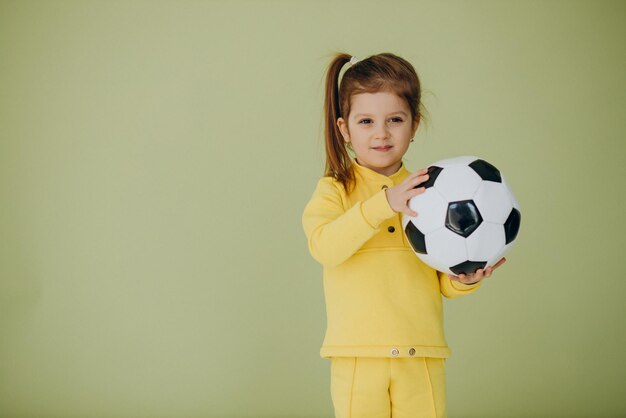 スタジオでサッカーボールを持つかわいい女の子