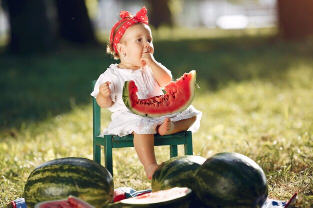 Cute little girl with watermelons in a park