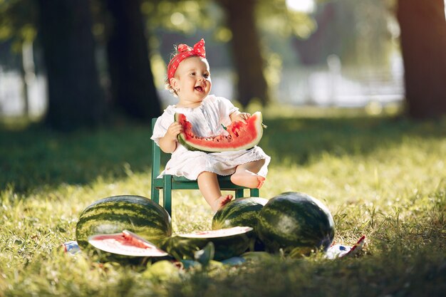 Cute little girl with watermelons in a park