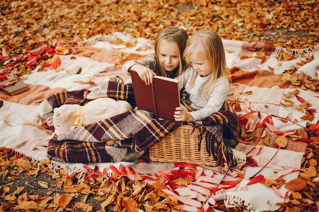 Bambine sveglie in un parco di autunno