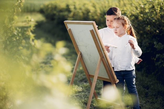 かわいい小さな子供たちが公園で絵を描く