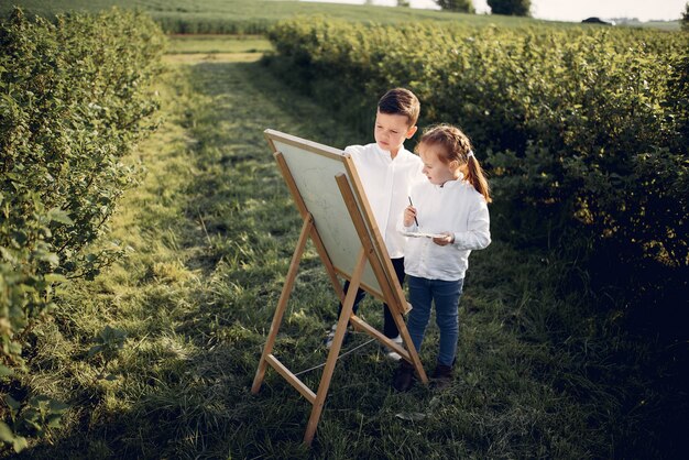 かわいい小さな子供たちが公園で絵を描く