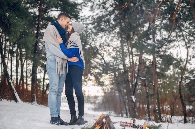 Cute and loving couple in a winter forest