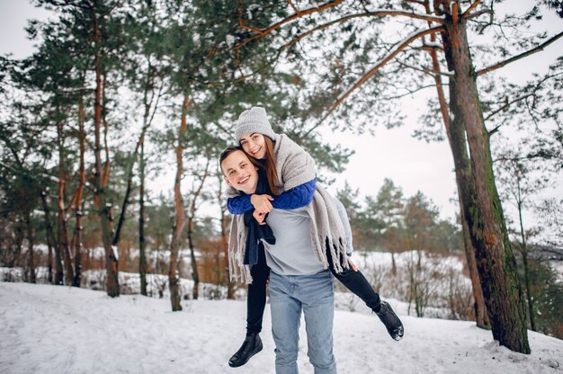 Cute and loving couple in a winter forest