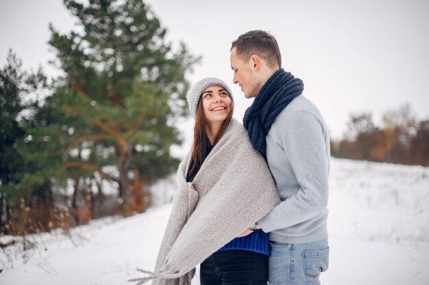 Cute and loving couple in a winter forest