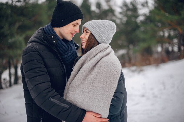 Cute and loving couple in a winter forest