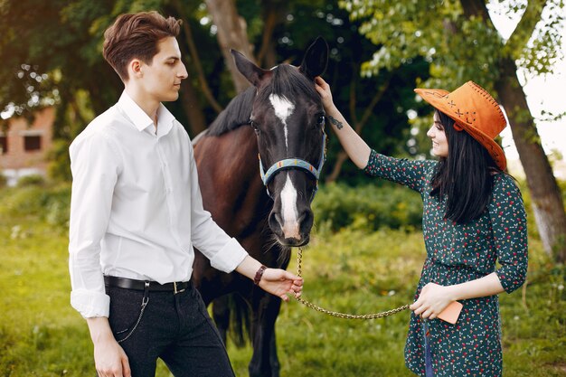 Cute loving couple with horse on ranch