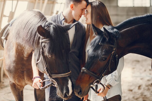 Cute loving couple with horse on ranch