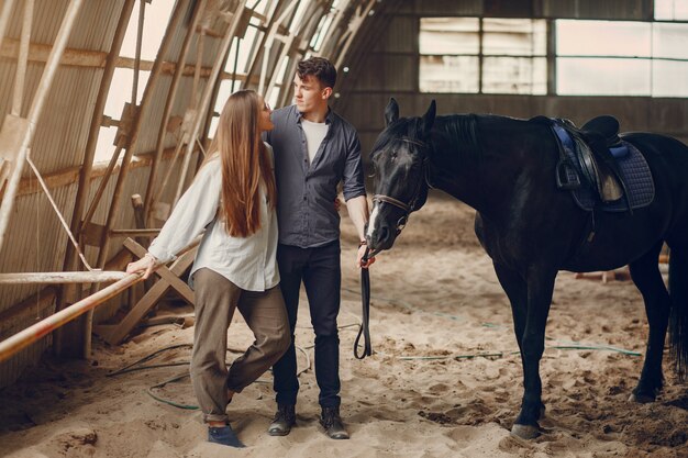 Cute loving couple with horse on ranch