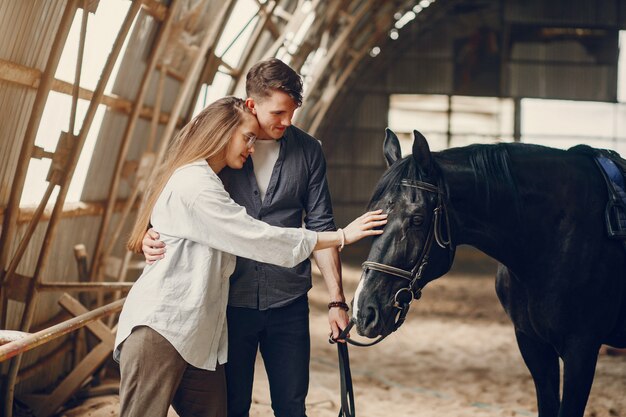 Милая влюбленная пара с лошадью на ранчо