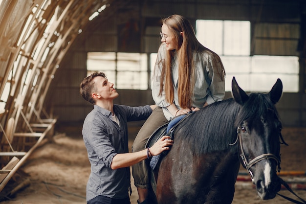 Cute loving couple with horse on ranch