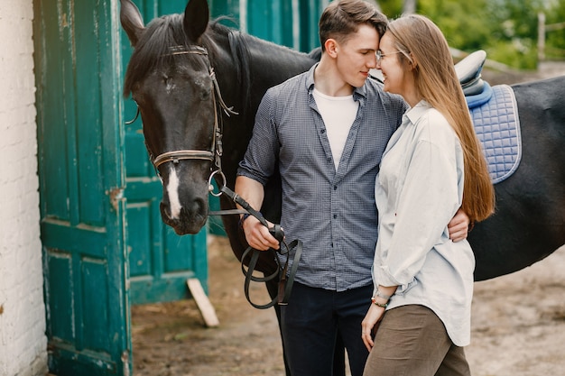 Cute loving couple with horse on ranch