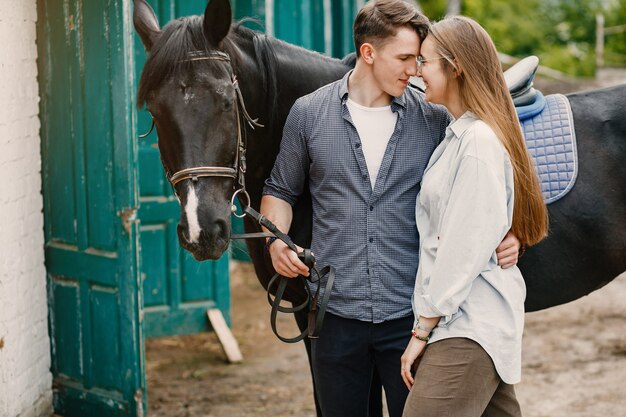 Cute loving couple with horse on ranch