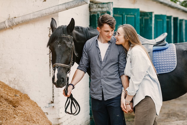 Cute loving couple with horse on ranch