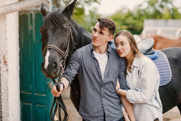 Cute loving couple with horse on ranch