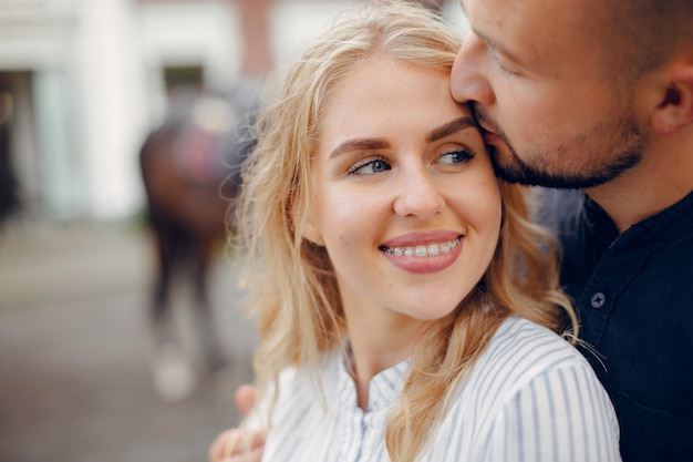 Cute loving couple with horse on ranch