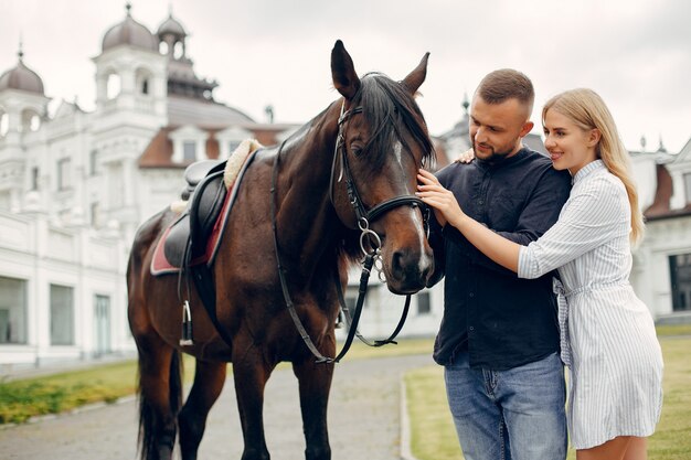 Cute loving couple with horse on ranch