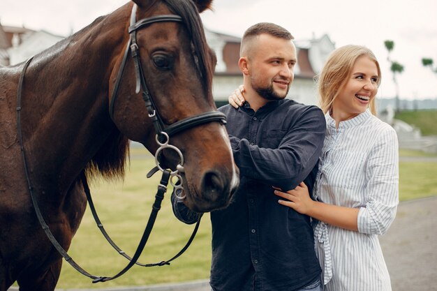 Cute loving couple with horse on ranch