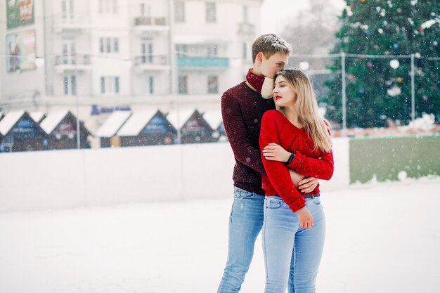 Cute and loving couplein a red sweaters in a winter city