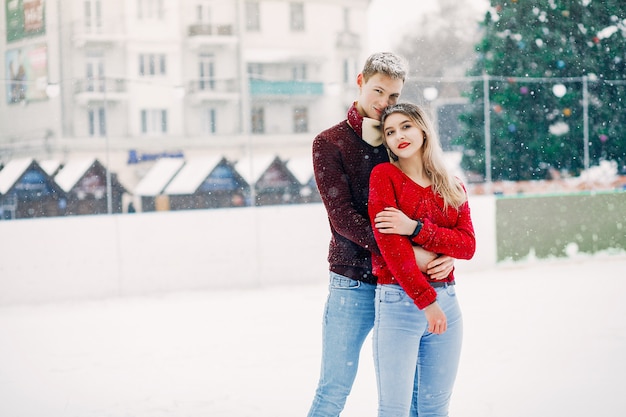 Cute and loving couplein a red sweaters in a winter city