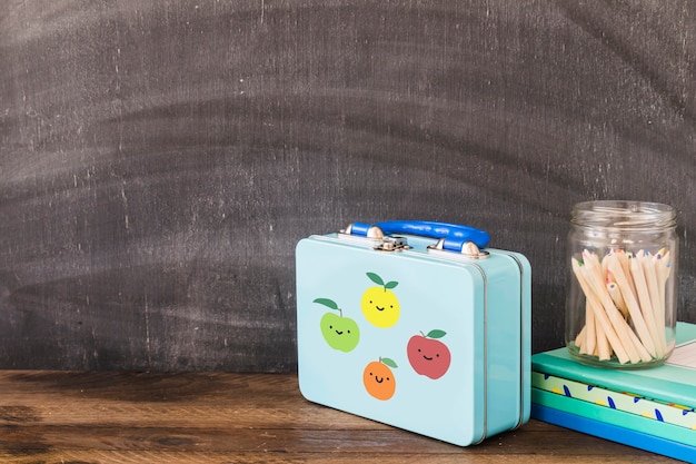 Cute lunchbox near pencils and notepads