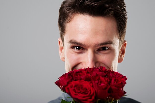 Cute man hiding behind flowers