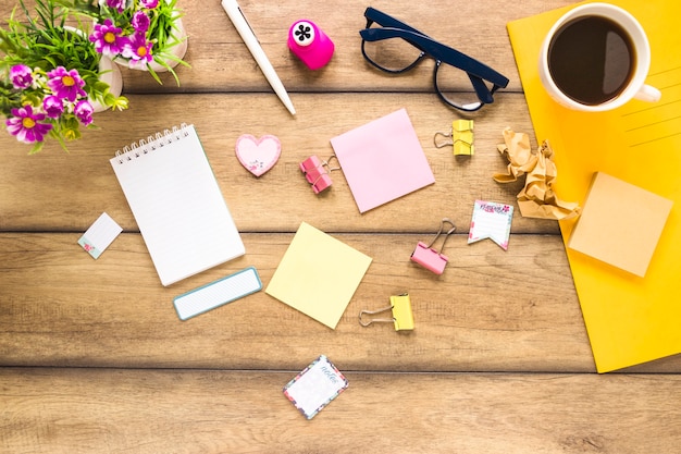 Carino posto di lavoro disordinato con caffè stazionario e fiori